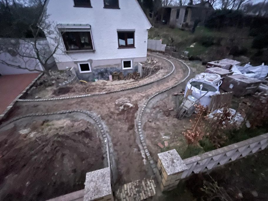 Neues Gartenlayout mit geschwungenen Wegen um ein Haus im Bau.